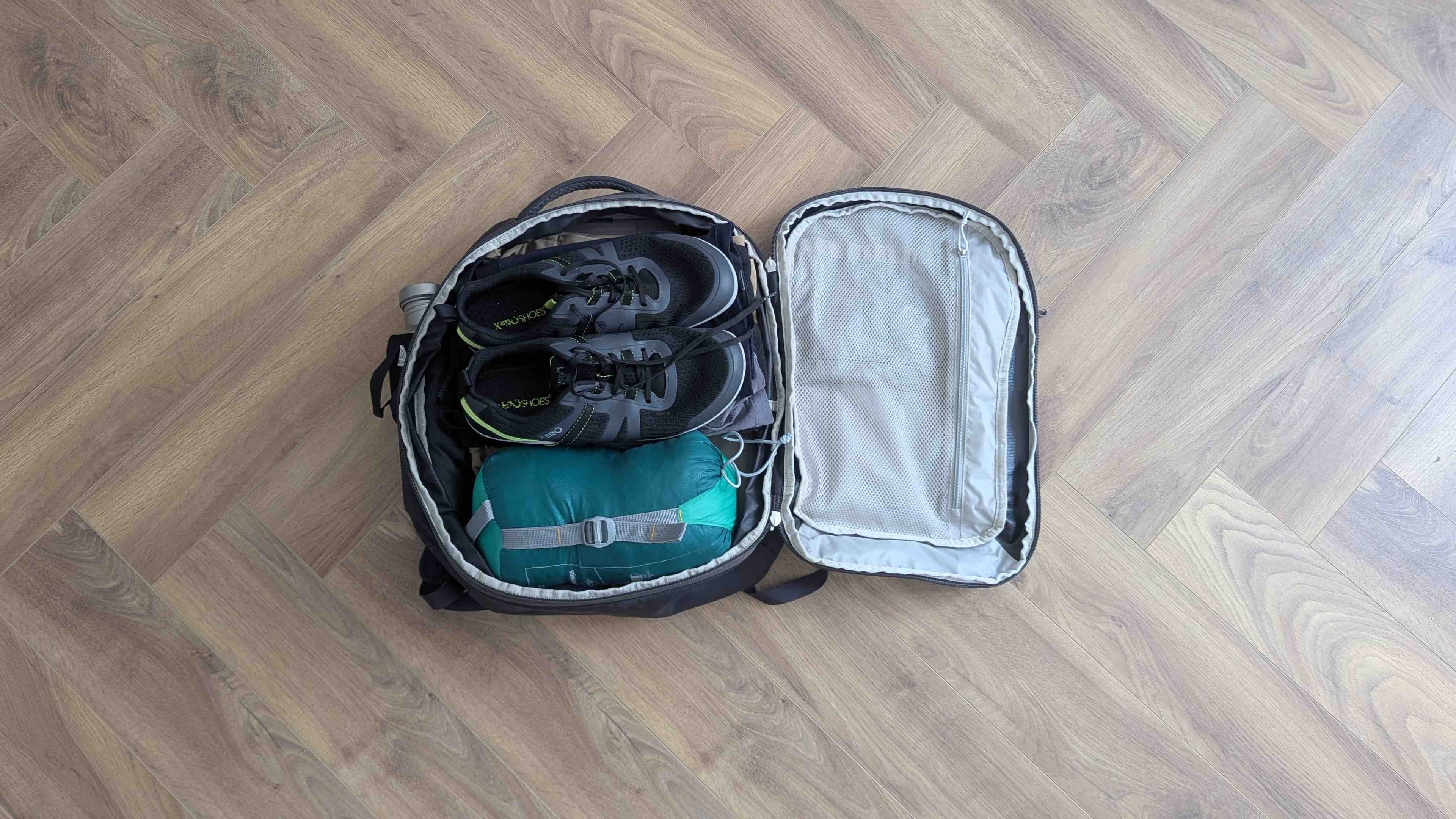 Intérieur du sac à dos Osprey Daylite 26+6L ouvert en mode clamshell, avec chaussures et duvet rangés à l'intérieur